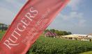 Photo of farm under partly cloudy skies with awnings in the distance and red Rutgers NJAES banner in foreground